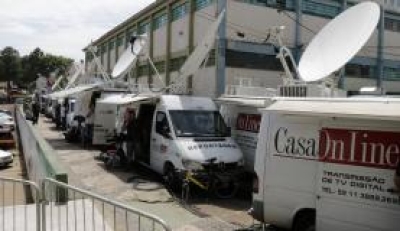 Carros de transmissão de televisão se preparam para cobertura de velório coletivo (Imagem: Daniel Isaia/Agência Brasil)