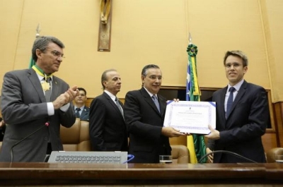 O filho de Henrique Prata recebe a homenagem das mãos do senador Eduardo Amorim (Foto: César de Oliveira)