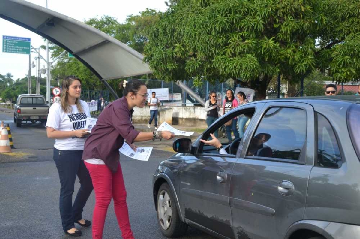 Manifestantes entregam panfletos na porta da UFS (Foto: Cássia Santana/Portal Infonet)