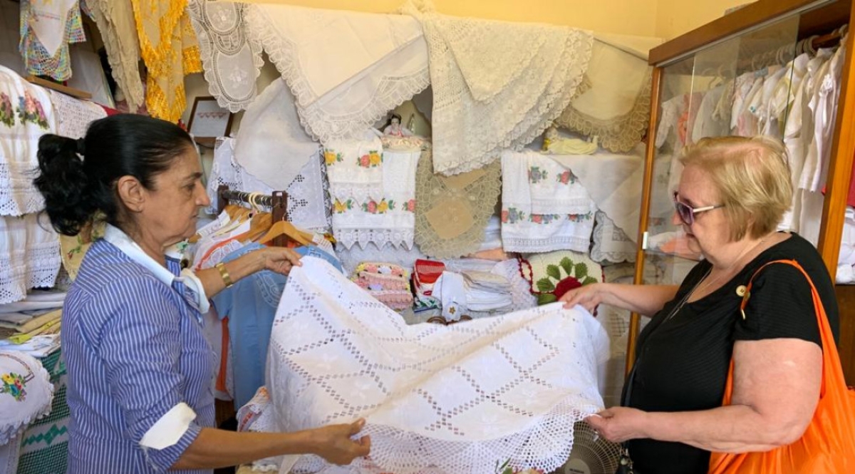 A professora aposentada Maria Teresa Mazali apreciando o artesanato sergipano - Foto: Max
Carlos | Governo de Sergipe